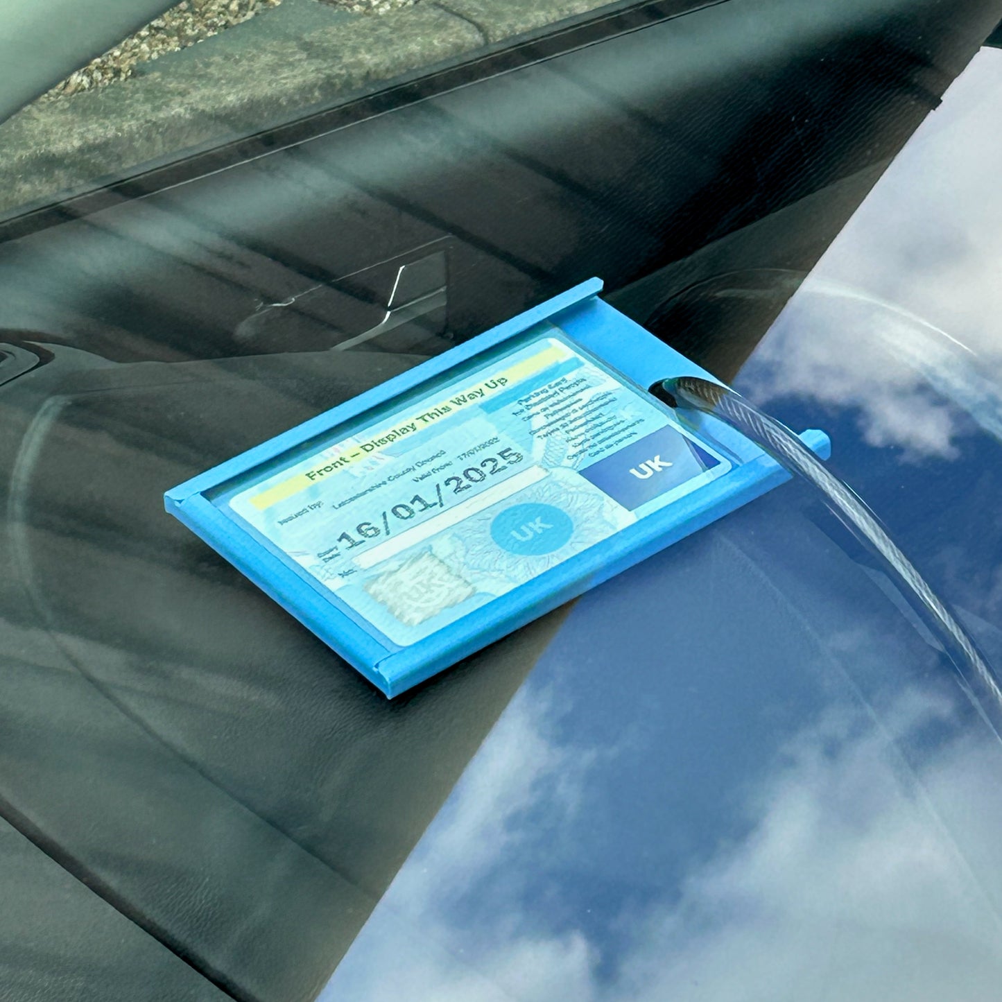 Blue badge protector device on a car's dashboard
