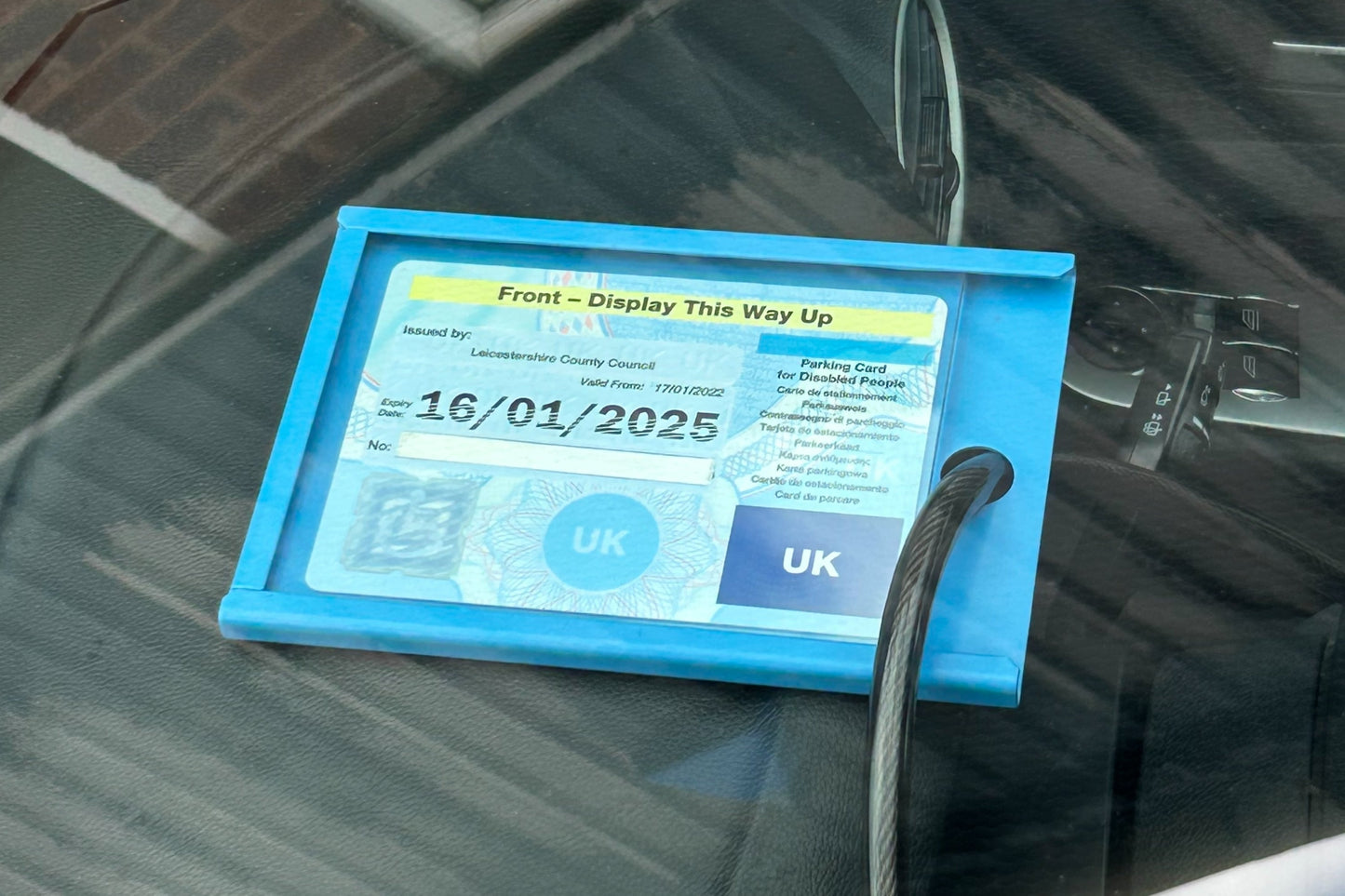Blue badge protector device on a car's dashboard